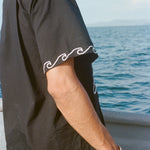 Image from the side of the white embroidered waves on the sleeve of the 'Unleashed' Shirt.