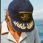 Zoomed in photo of the model wearing 'The Explorers Club' 6-Panel Souvenir Cap.  