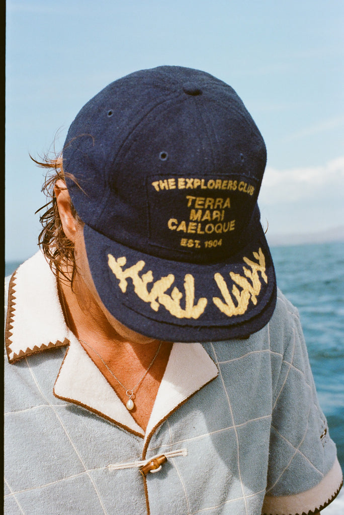Zoomed in photo of the model wearing 'The Explorers Club' 6-Panel Souvenir Cap.  
