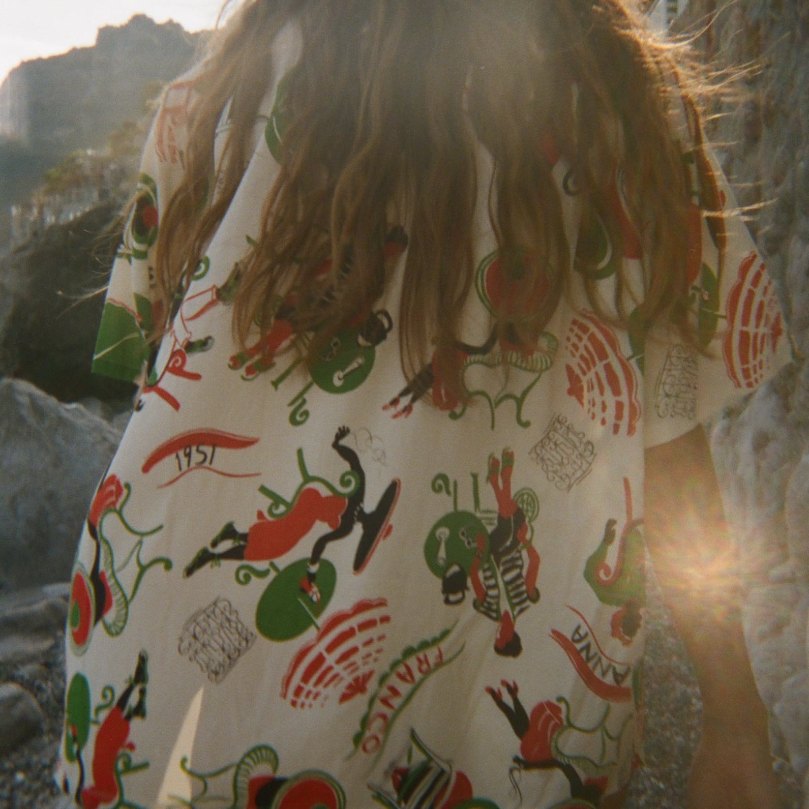Person wearing a colorful shirt, walking away from the camera. 