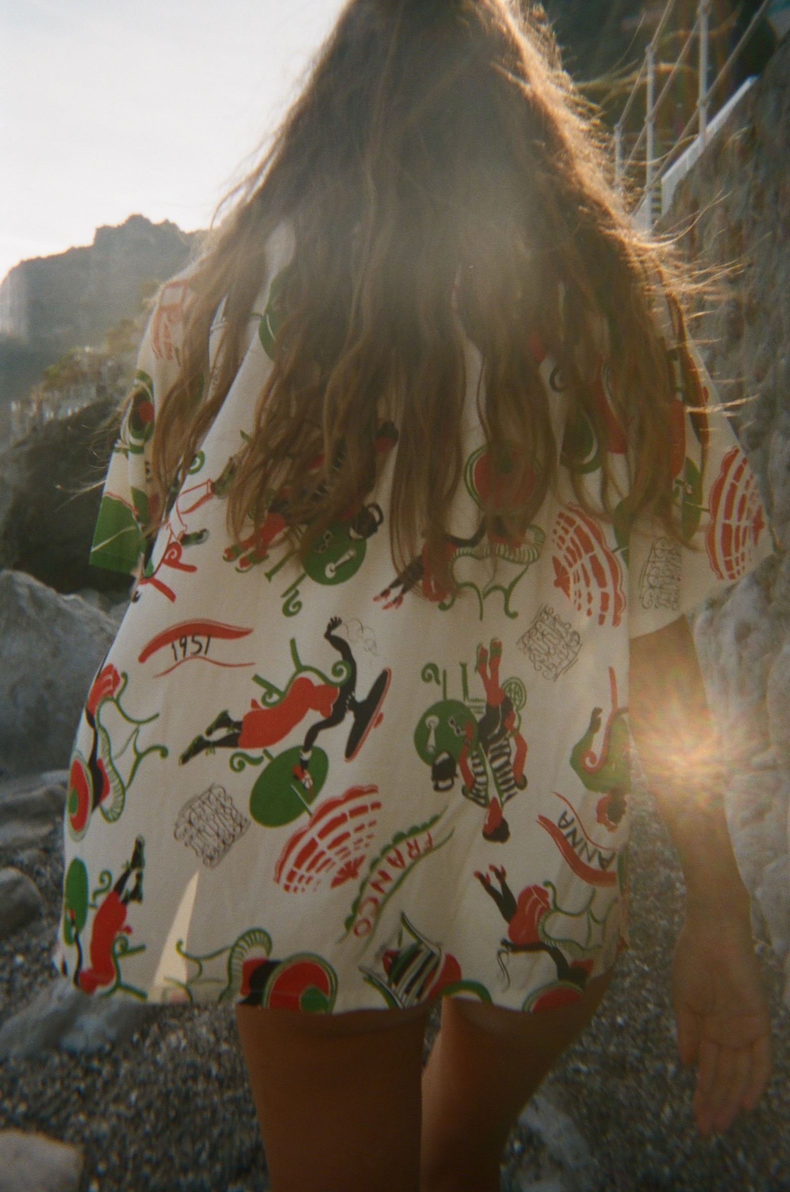 Person wearing a colorful shirt, walking away from the camera. 