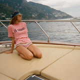 Woman sitting on a boat deck with scenic background