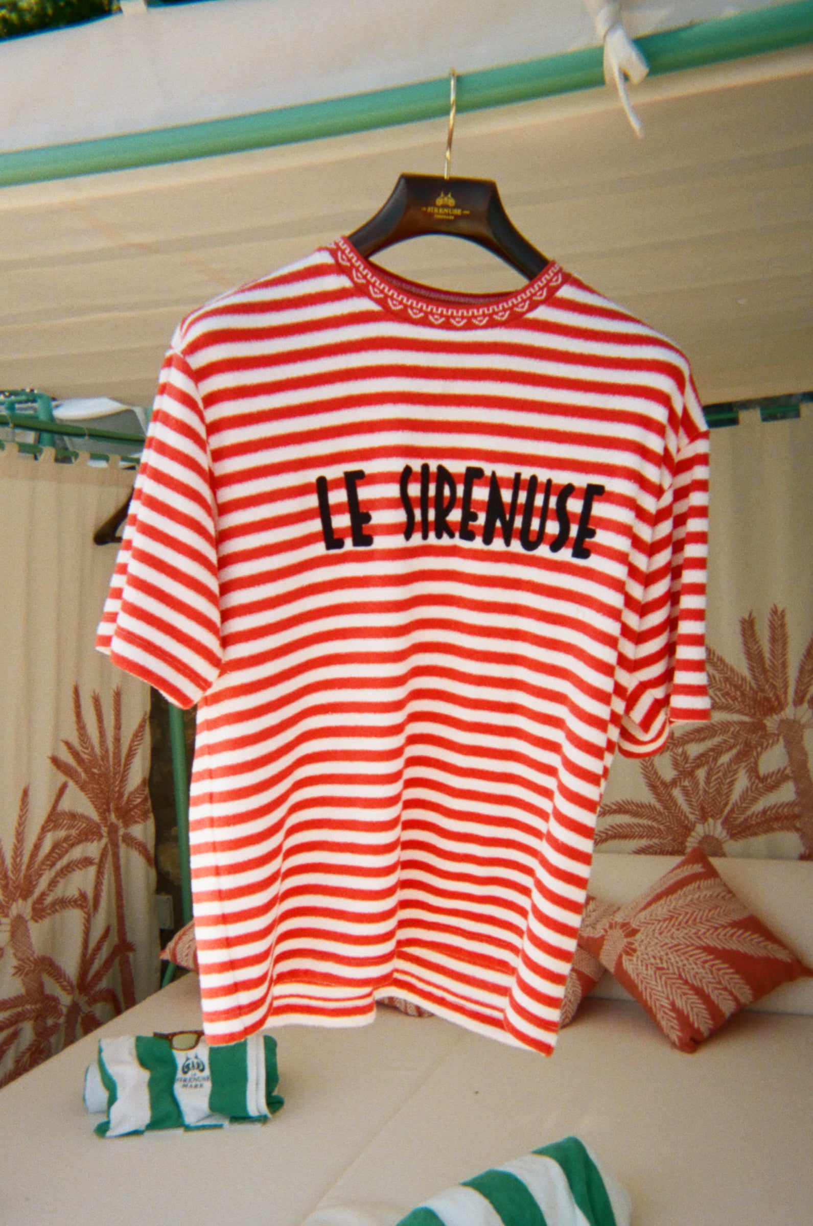 Red and white striped t-shirt with 'LE SIRENUSE' text on a hanger.