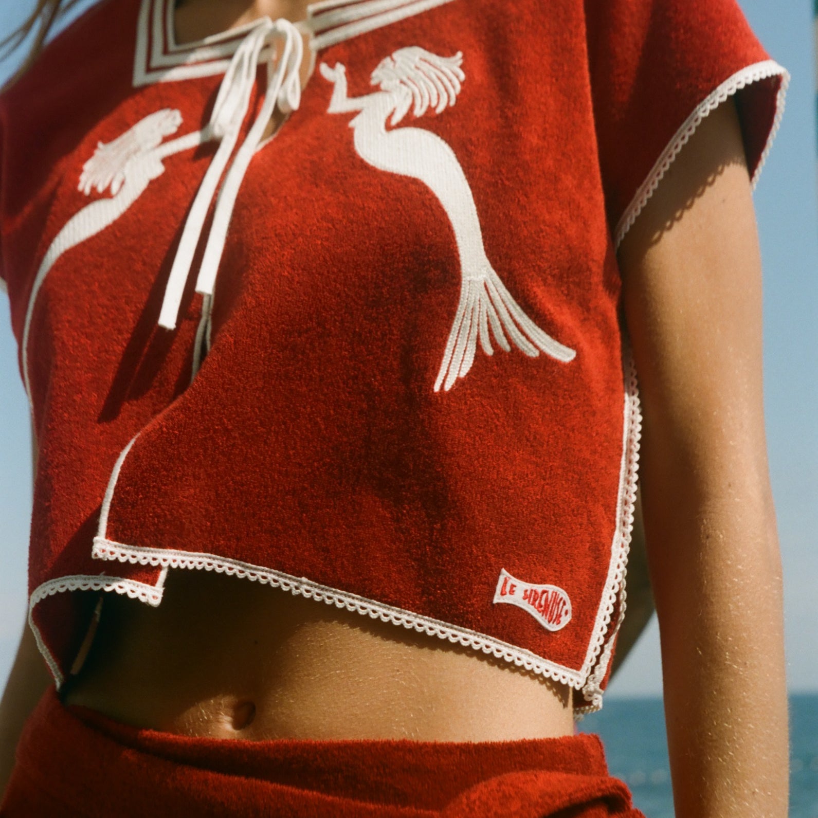 Red towel top with mirrored mermaid design.