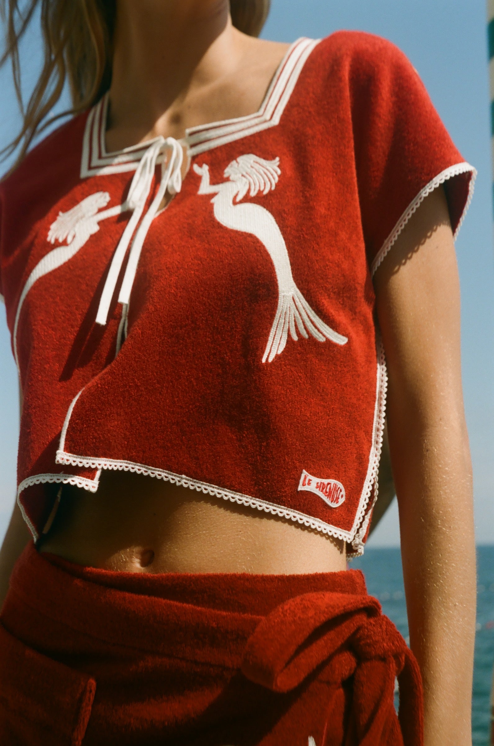 Red towel top with mirrored mermaid design.
