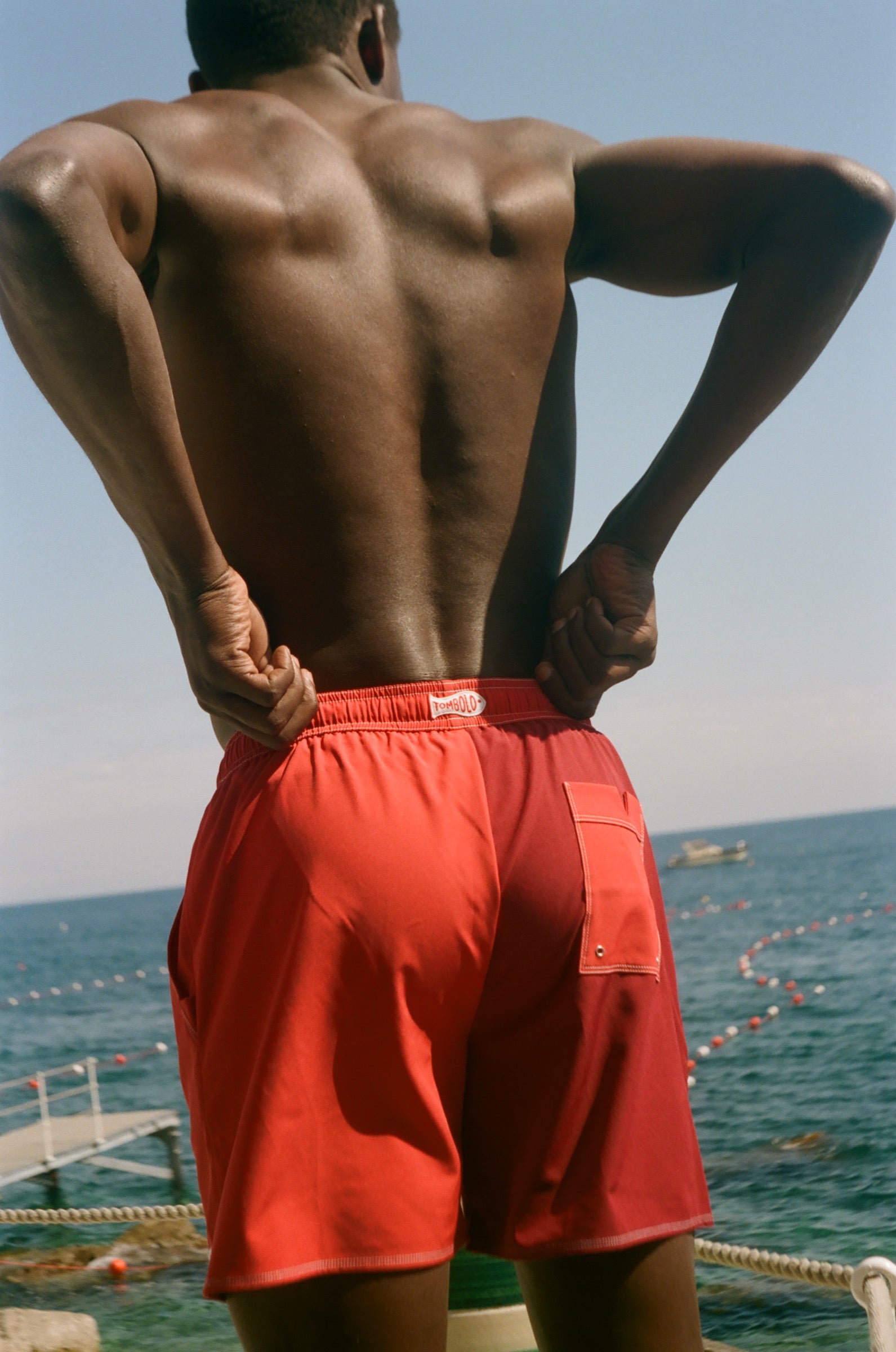 Man wearing red Le Sirenuse swim shorts.