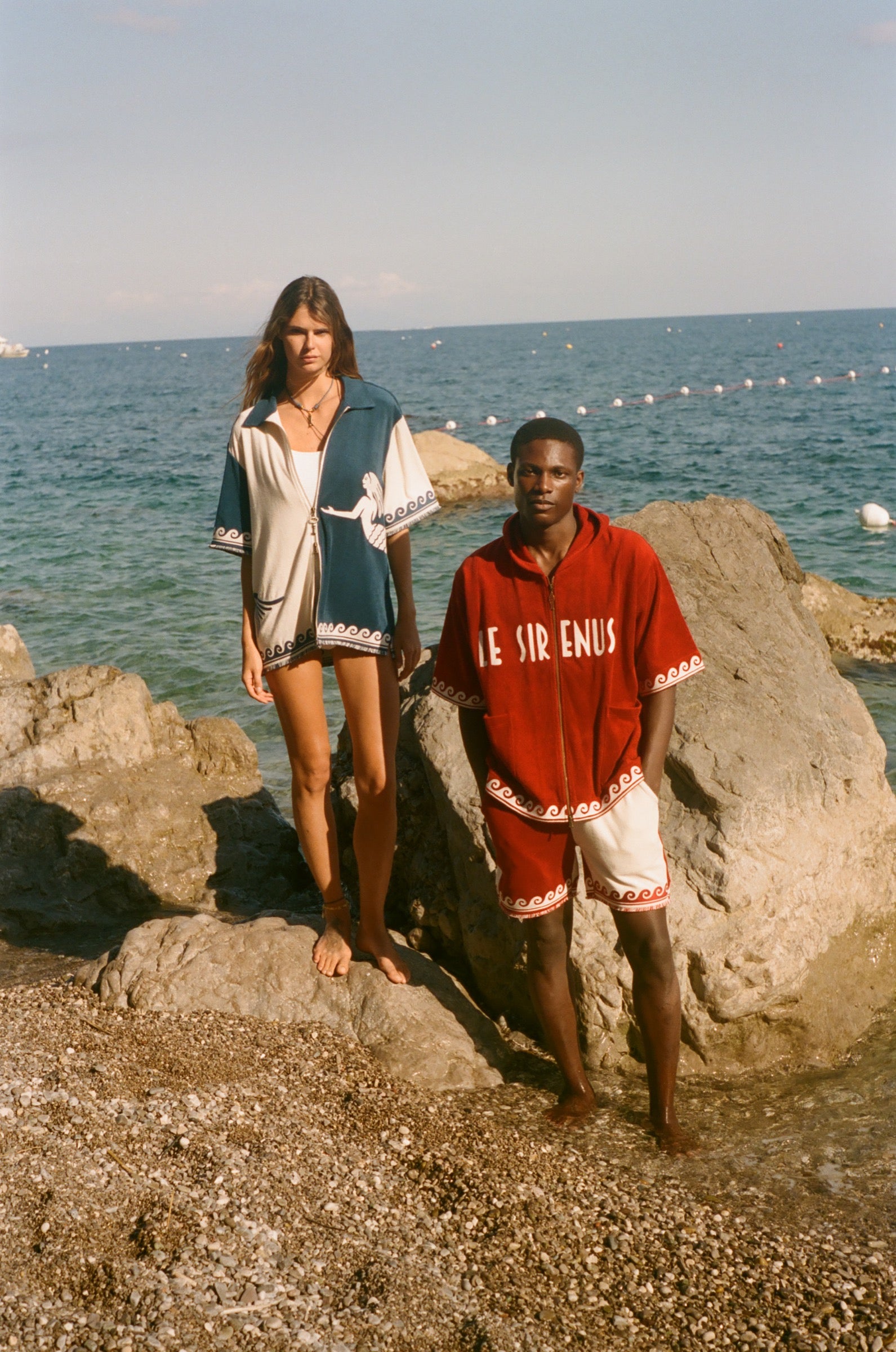 Two people standing on the beach, wearing the Le Sirenuse Checkout Cabana sets. 