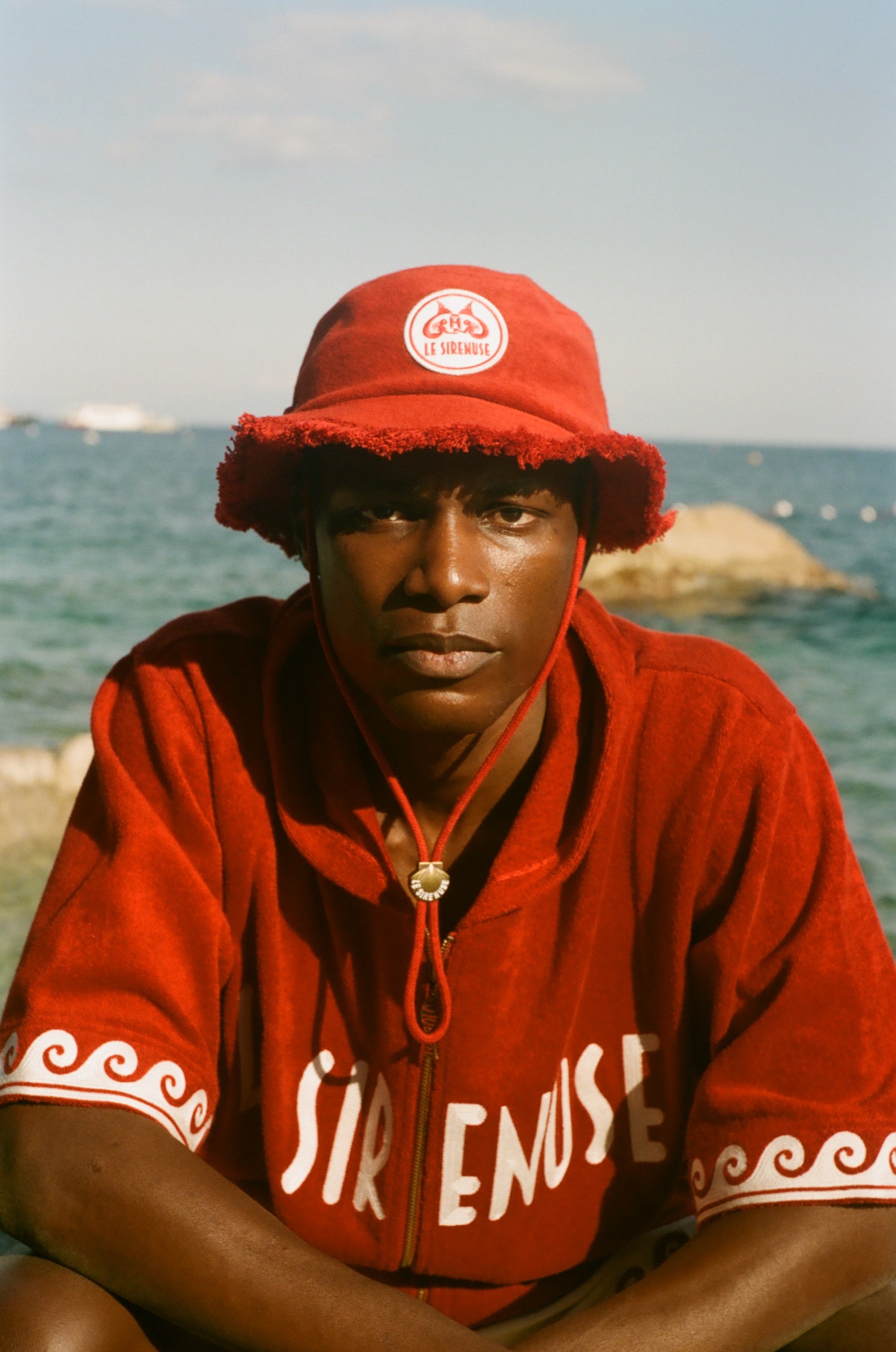 Man wearing red terry cloth Le Sirenuse bucket hat.