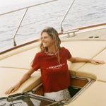 Woman in a red Le Sirenuse shirt on a boat 