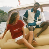 Two people sitting on a boat with scenic background.