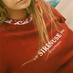 Close-up of woman wearing Le Sirenuse tee sitting on a boat.