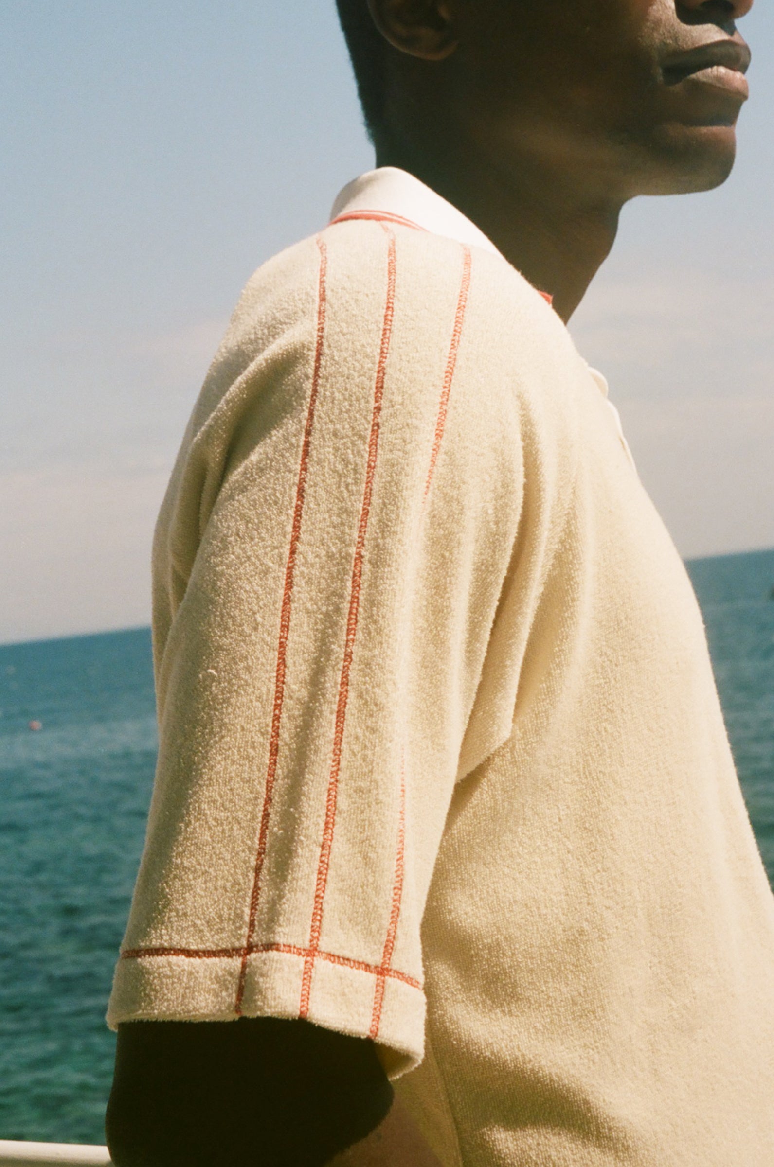 Close-up of red piping detailing on the Le Sirenuse polo shirt.