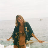 Woman in a leopard print bikini and Le Sirenuse 'Don't Worry' crop cut. 