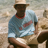 Person wearing a striped shirt and hat by the water