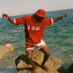 Man wearing Le Sirenuse Cabana and matching bucket hat at the beach.