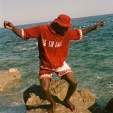 Man wearing Le Sirenuse Cabana and matching bucket hat at the beach.