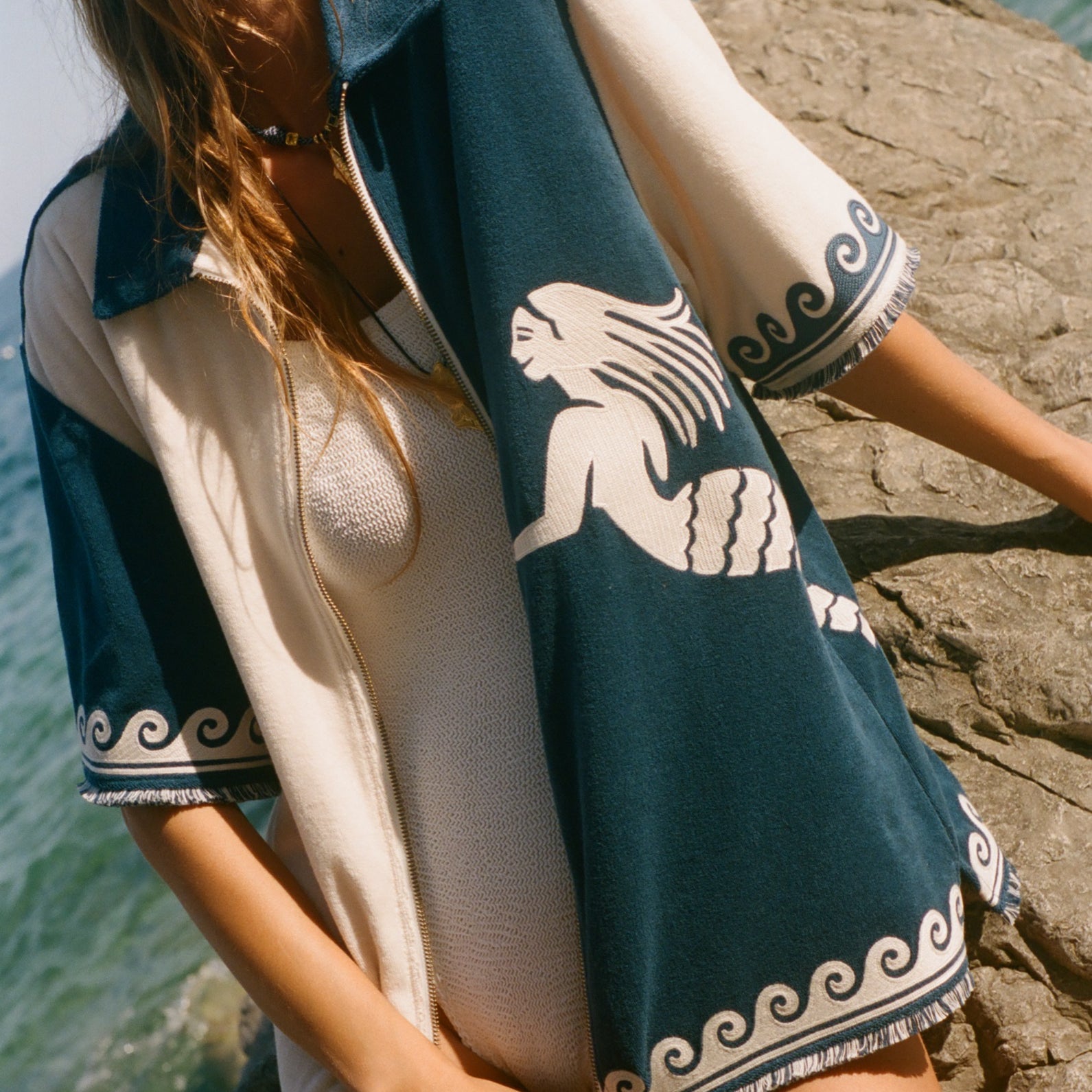 Woman wearing Le Sirenuse Late Checkout cabana shirt over a white swimsuit.