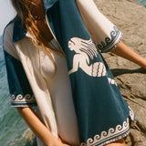 Woman wearing Le Sirenuse Late Checkout cabana shirt over a white swimsuit.