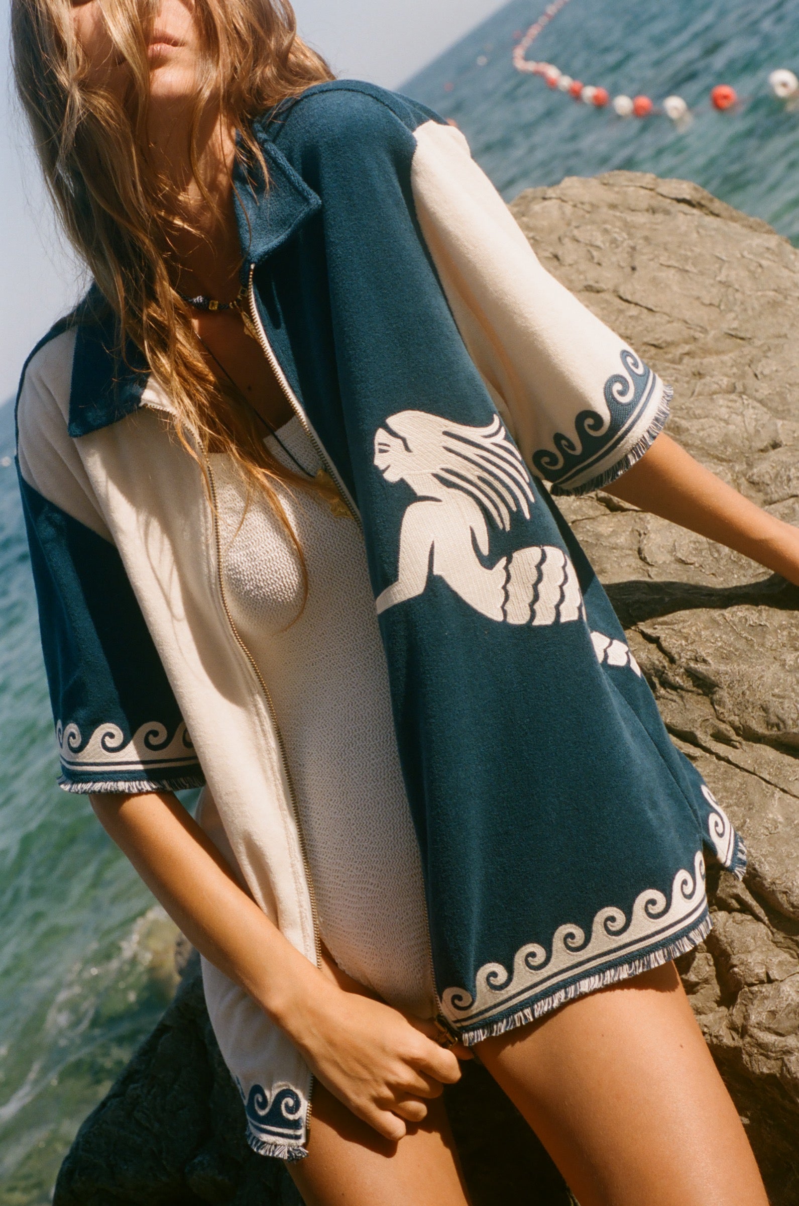 Woman wearing Le Sirenuse Late Checkout cabana shirt over a white swimsuit.