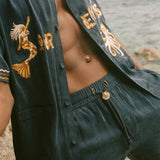 Person wearing a dark blue matching set with gold embroidery.