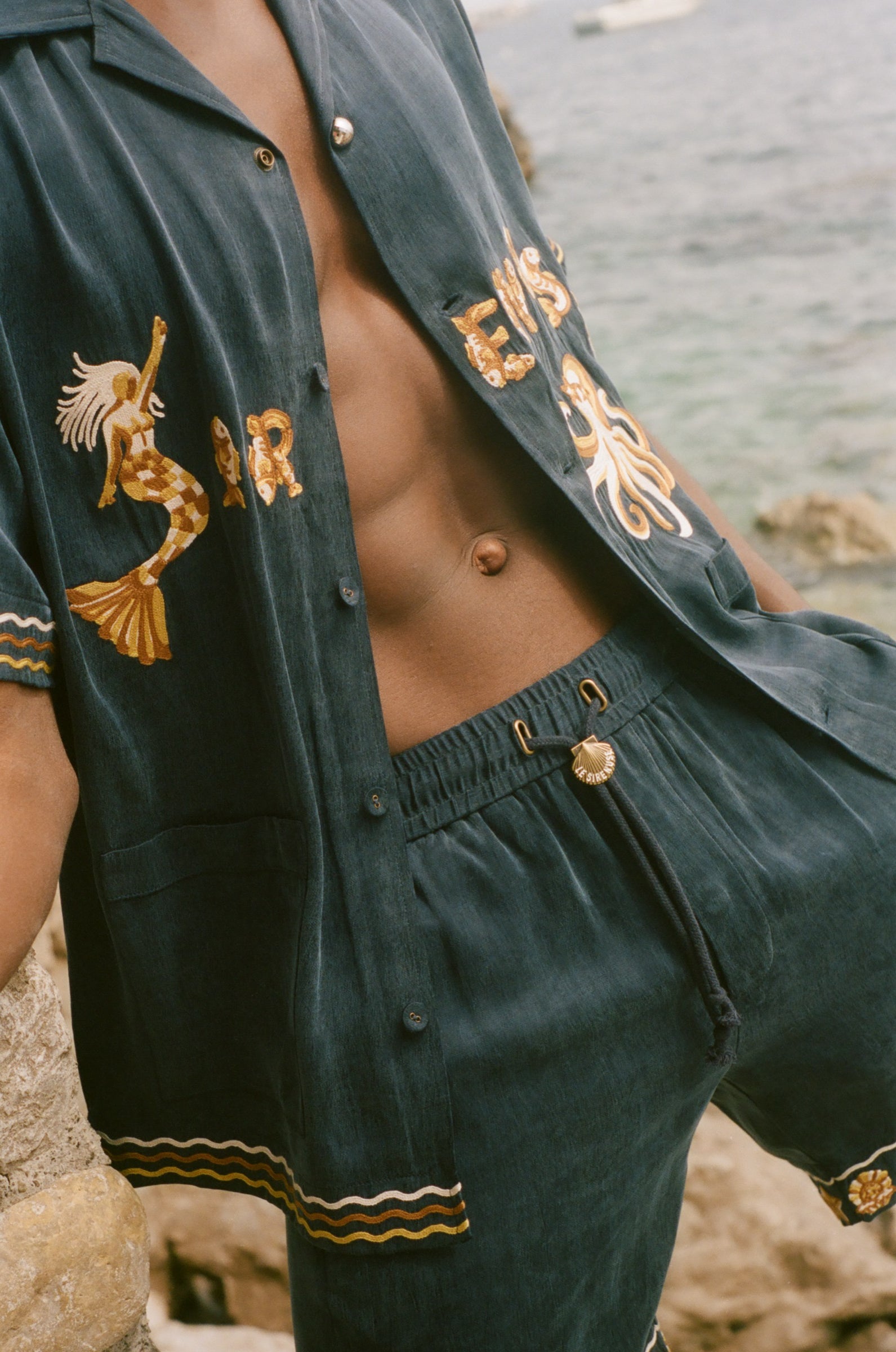 Person wearing a dark blue matching set with gold embroidery.