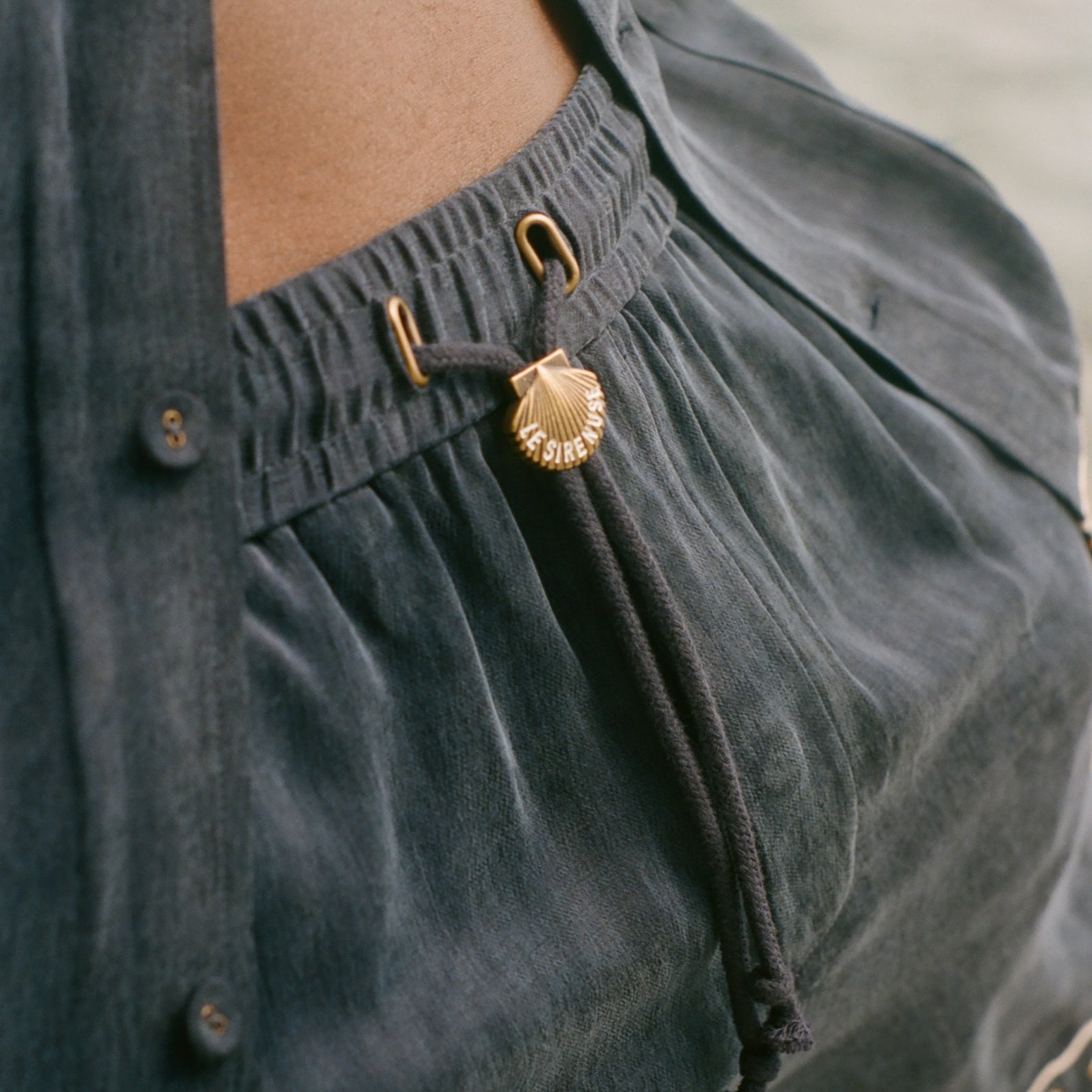 Close-up of dark blue shorts with gold decorative elements.