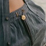 Close-up of dark blue shorts with gold decorative elements.