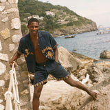 Man standing on rocks wearing Don't Worry matching set.