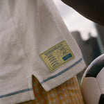 Close-up of a match schedule label on a white garment with a blurred background