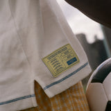 Close-up of a match schedule label on a white garment with a blurred background