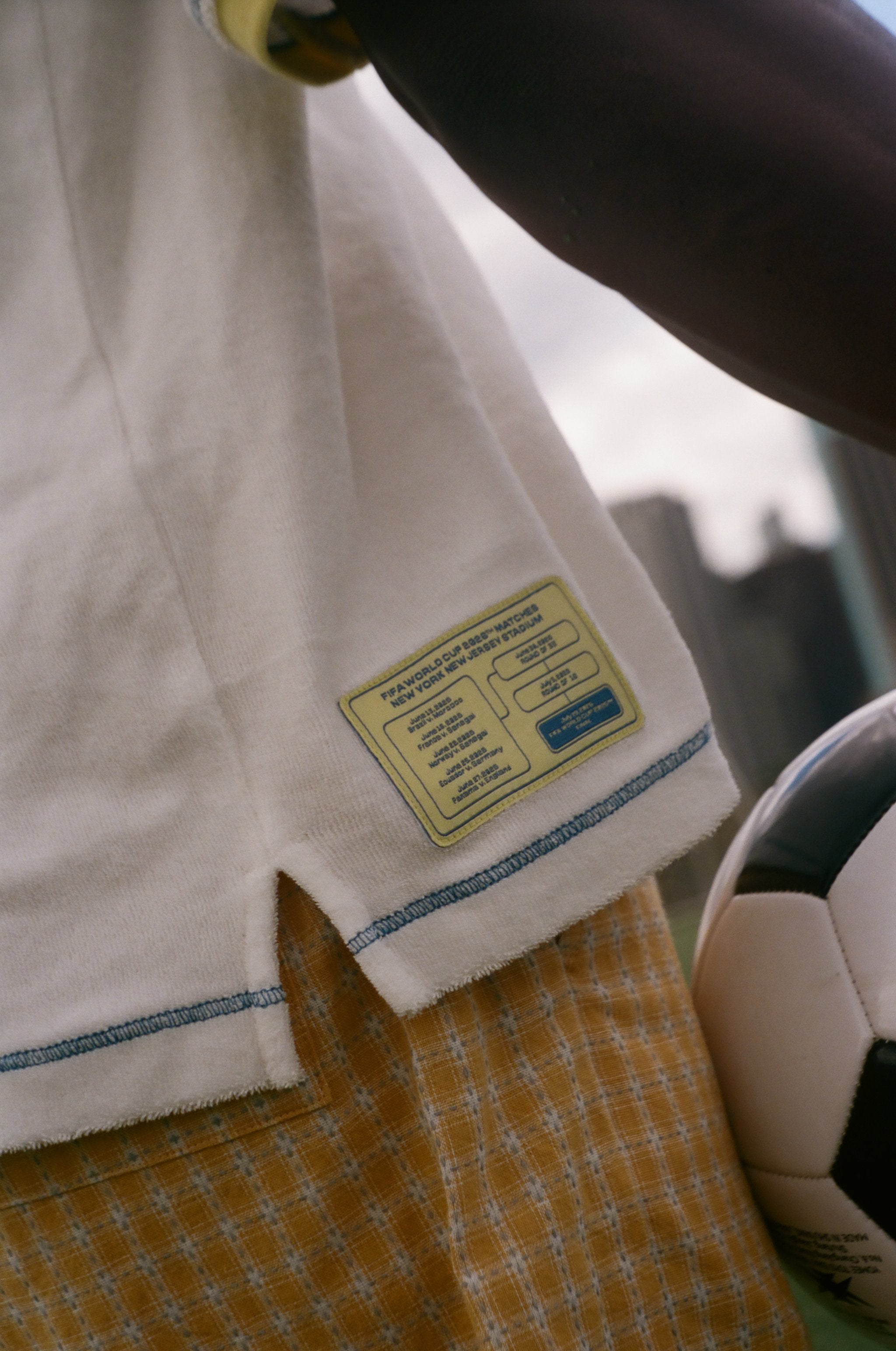 Close-up of a match schedule label on a white garment with a blurred background