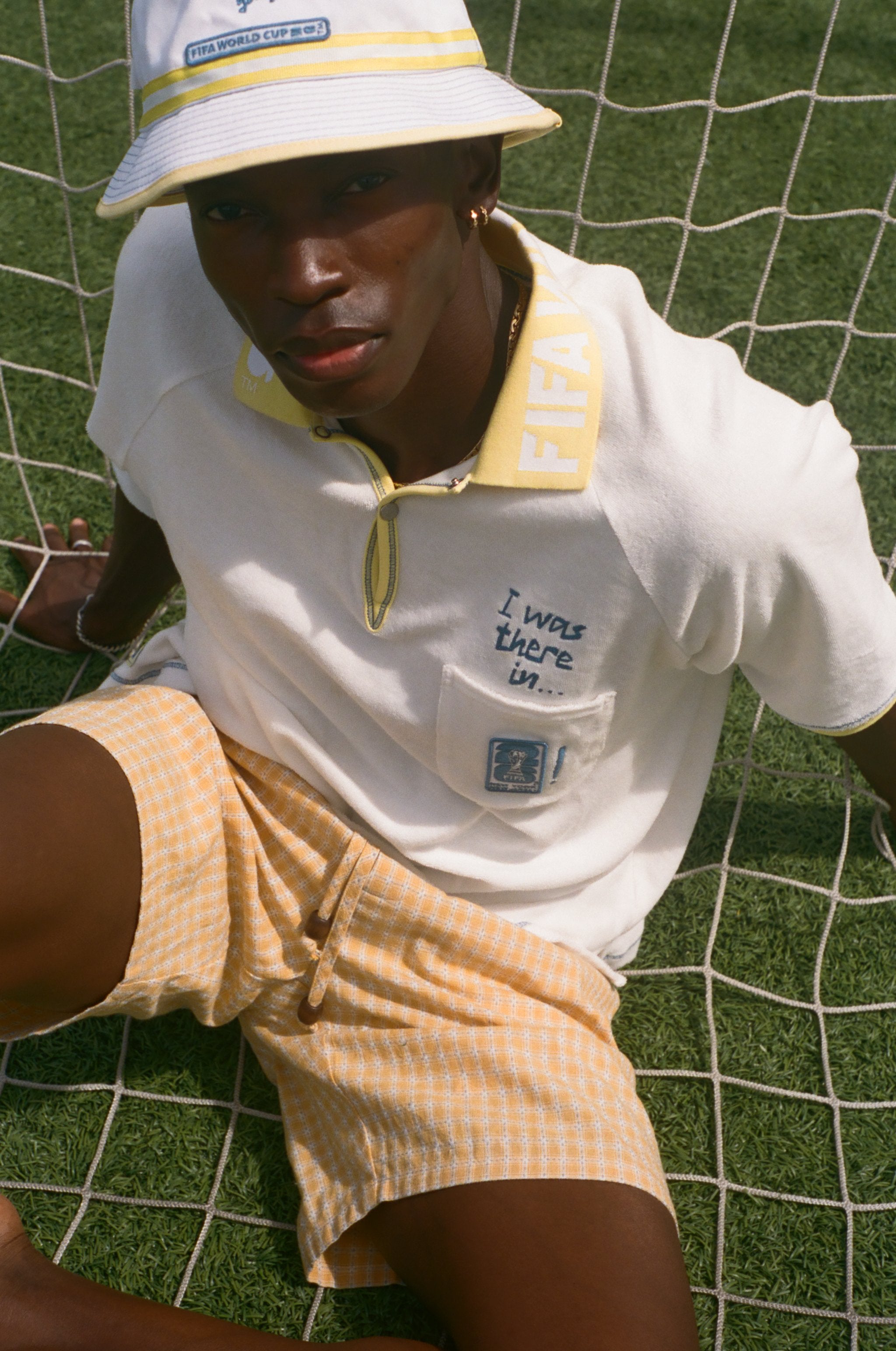 Man wearing FIFA Polo shirt, with 'I was there in..." chain-stitch embroidery over the chest pocket. He is also wearing a matching bucket hat.