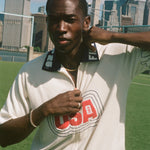 Person wearing a white 'USA' cabana shirt with a city skyline in the background