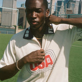 Person wearing a white 'USA' cabana shirt with a city skyline in the background