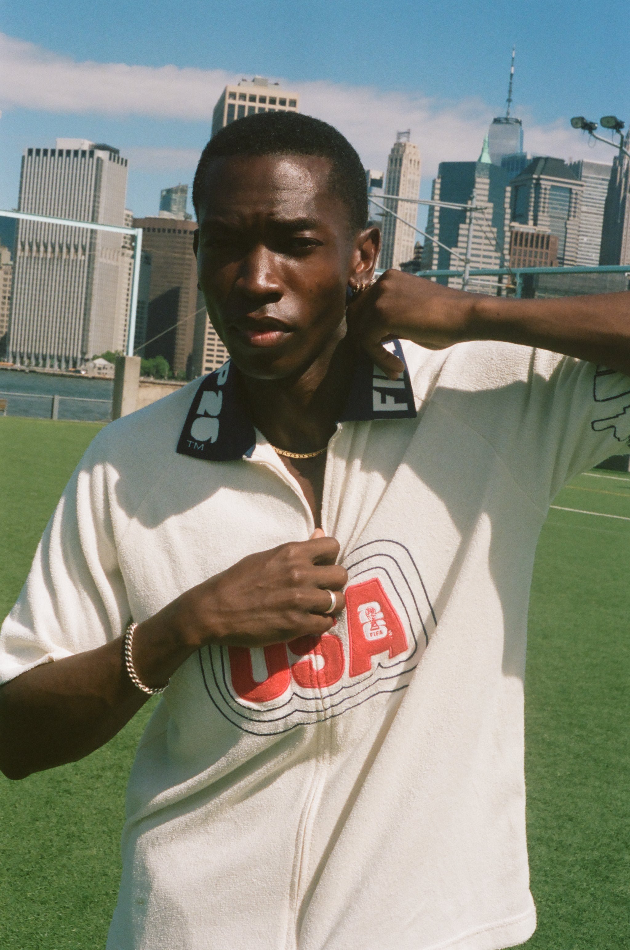 Person wearing a white 'USA' cabana shirt with a city skyline in the background