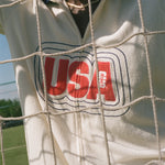 Close-up of a white cabana with 'USA' printed on it, through a net.