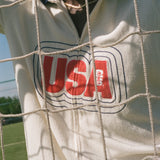Close-up of a white cabana with 'USA' printed on it, through a net.