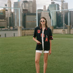 Person wearing a 'USA' cabana with a soccer ball on a soccer field with city skyline in the background