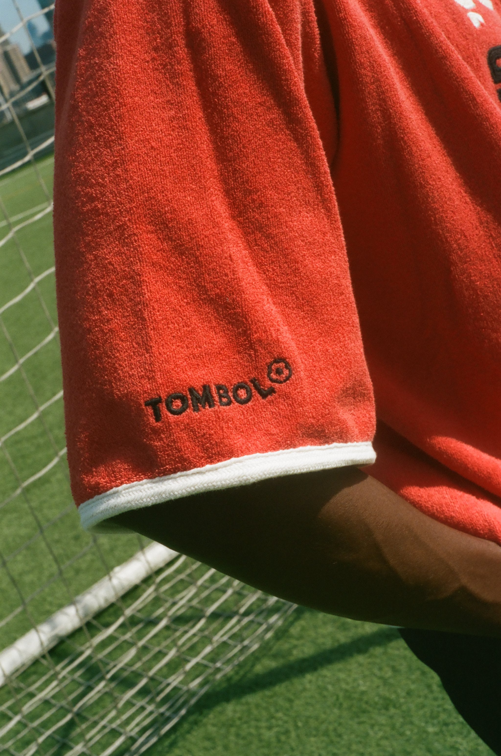 Red cabana with 'Tombolo' logo on the wearer's sleeve. 