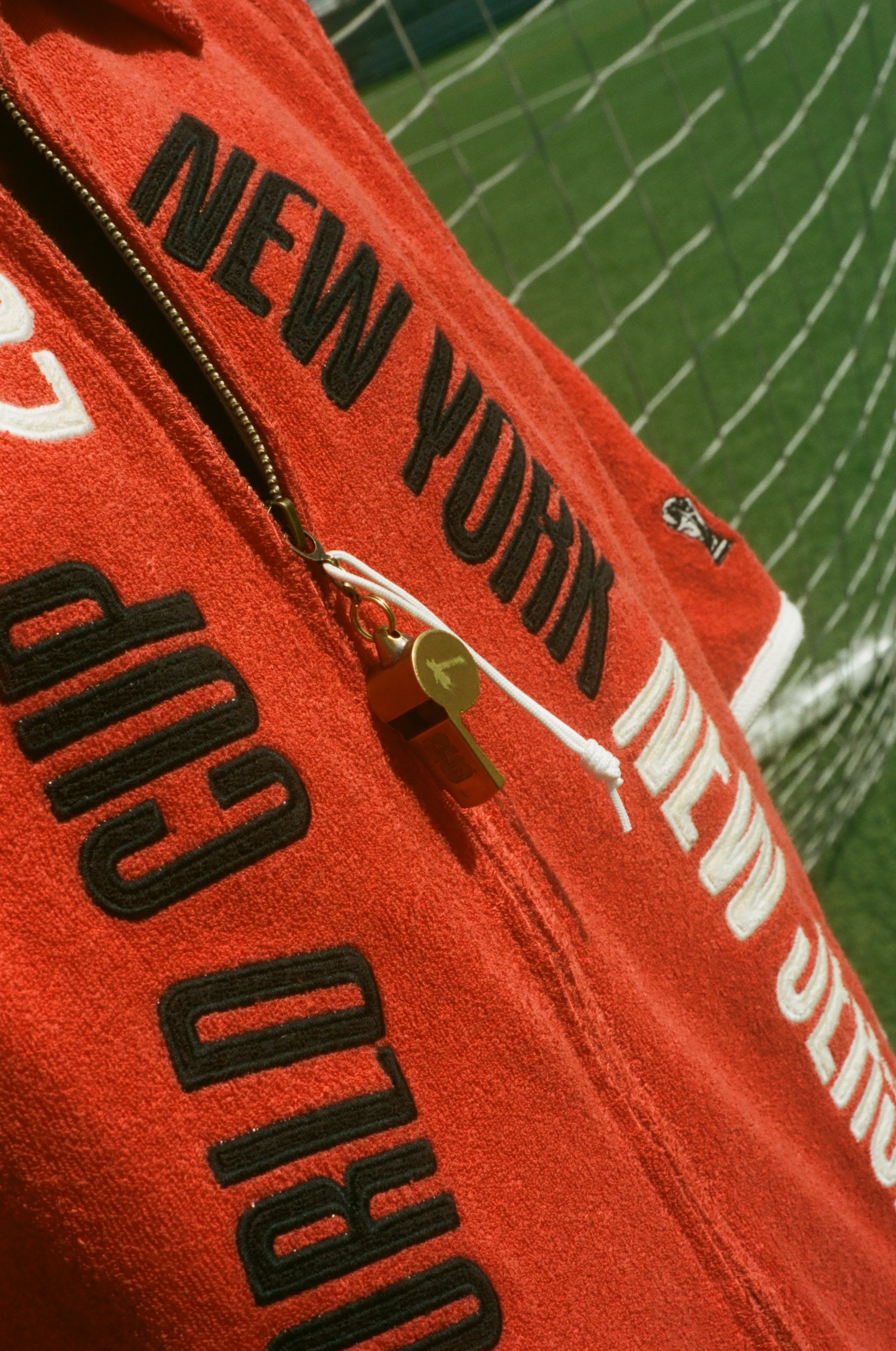 Close-up of the zipper pull: an antique-looking whistle.