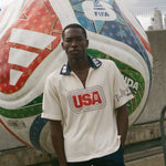 Man standing in front of a large soccer ball with FIFA branding, wearing Tombolo USA cabana. 