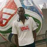 Man standing in front of a large soccer ball with FIFA branding, wearing Tombolo USA cabana. 