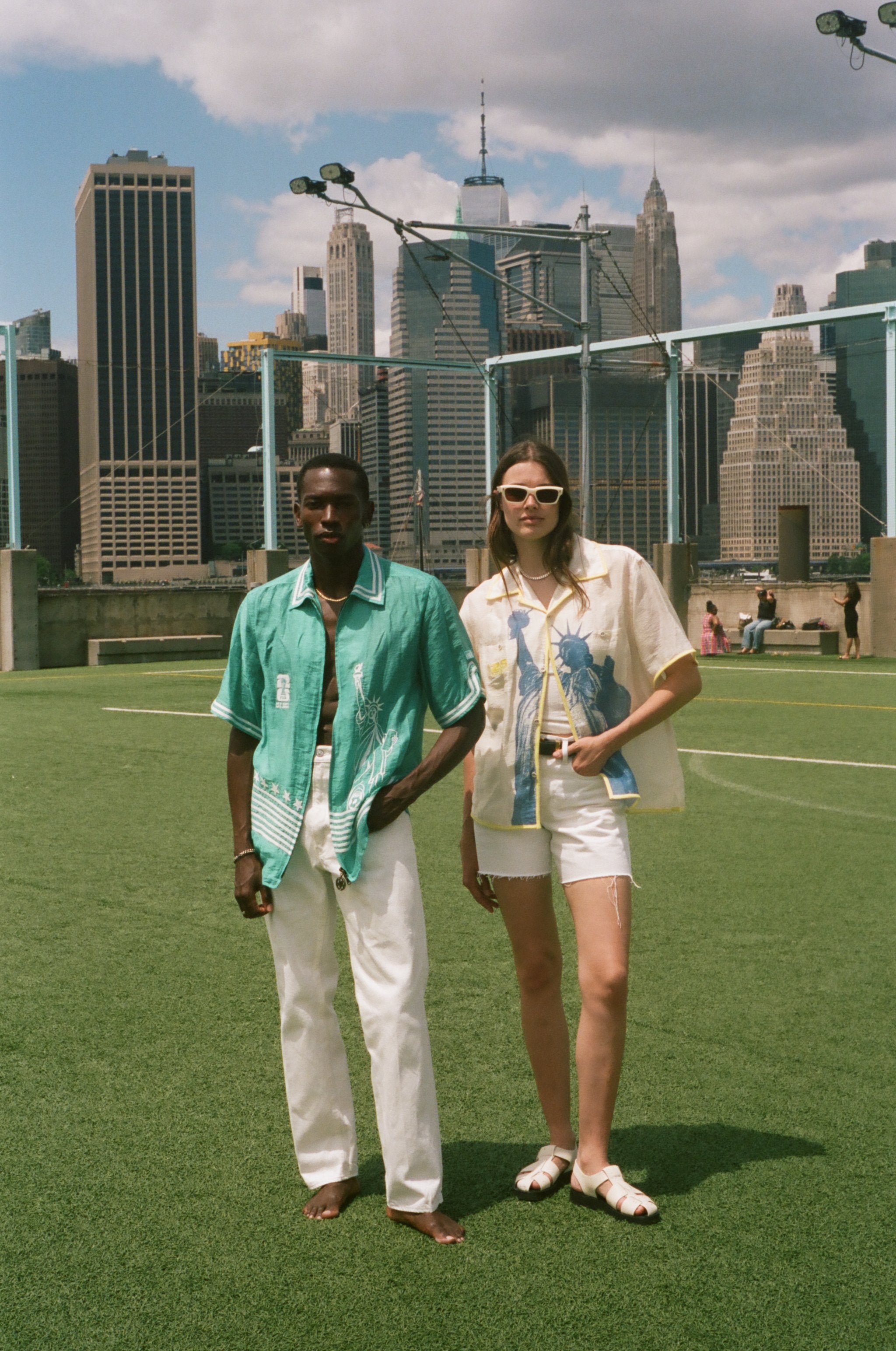 Two people standing on a soccer field, wearing items from the FIFA and Tombolo collection. 