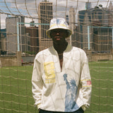 Person wearing a white terry cloth long sleeve shirt and bucket hat with city skyline in the background