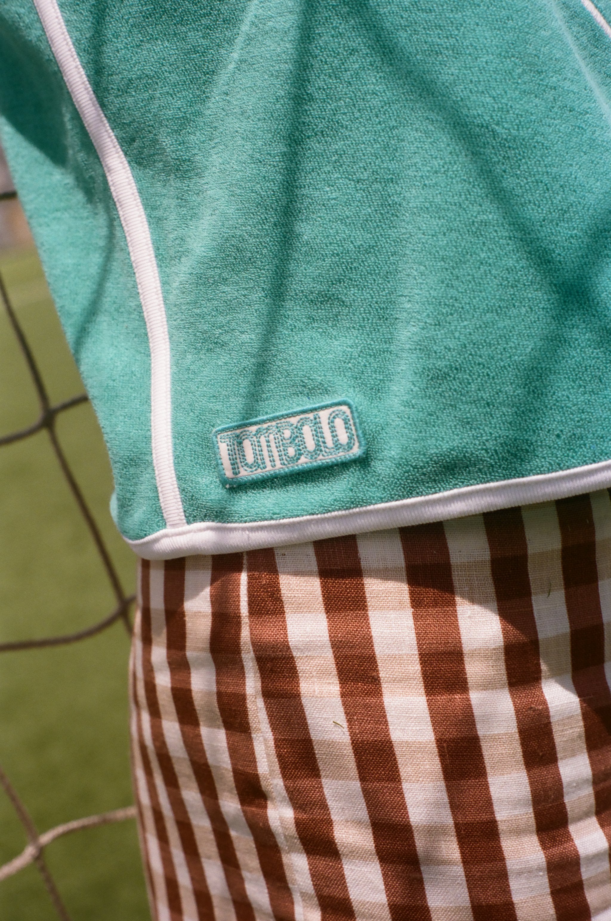 Close-up of Tombolo logo on the teal FIFA hand towel top.