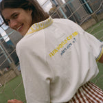 Woman showing off the back of her FIFA world cup cabana shirt. 