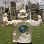 Man showing off the back off his FIFA World Cup long sleeve cabana shirt and bucket hat. 