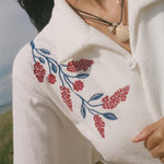 Close-up on the shoulder flower vine embroidery detail.