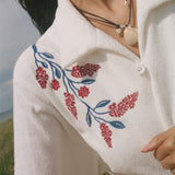 Close-up on the shoulder flower vine embroidery detail.