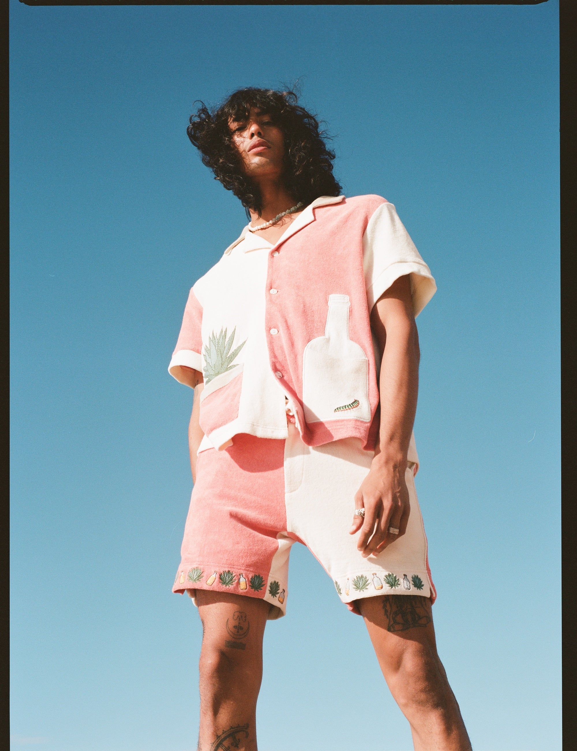 Male Model pictured from below, wearing full 'Gusanito' Cabana Set with his brown hair blowing in the wind.